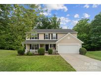 Charming two-story home with a well-manicured lawn and a cozy front porch at 4002 Paddle Wheel Ln, Indian Trail, NC 28079