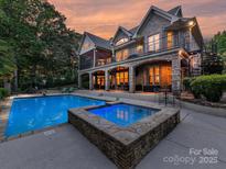 Stunning backyard with a beautiful pool, hot tub, and spiral staircase leading to the upper level of the house at 4290 Barbrick St, Sherrills Ford, NC 28673