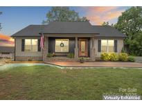 Charming single-story home with brick accents, a decorative front door, and an American flag at 632 Skyland N Dr, Mount Pleasant, NC 28124
