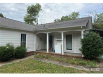Charming white home featuring a covered porch, updated windows, and neatly manicured landscaping at 6507 Chewink Ct, Charlotte, NC 28227