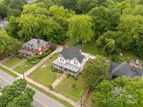 Expansive aerial view of a beautiful home surrounded by lush green trees and a well-manicured lawn at 7 Kings Mountain St, York, SC 29745
