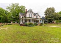 Charming two-story house boasts a large front yard with mature trees and a classic, inviting exterior at 7 Kings Mountain St, York, SC 29745
