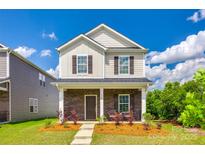 Charming two-story home featuring stone accents, a cozy porch, and manicured landscaping at 700 Windage Way, Pineville, NC 28134