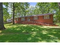 Charming brick home with a beautifully landscaped front yard and a welcoming entrance with brick steps at 800 Davenport St, Monroe, NC 28112