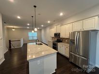 Bright kitchen boasts an island with granite countertop, stainless appliances, and ample cabinet storage at 9236 Ainslie Downs St, Charlotte, NC 28273