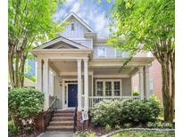 Charming home featuring a covered front porch, brick stairs, and meticulously maintained landscaping at 7023 Blakeney Greens Blvd, Charlotte, NC 28277
