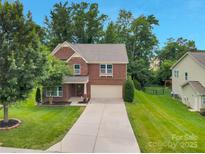 Charming two-story brick home with a well-manicured lawn and an inviting driveway at 1017 Quail Run Ct, Indian Land, SC 29707