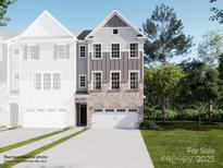 New construction townhome showing exterior with brick and siding and a two-car garage and landscaping at 1021 Bandon Dr, Waxhaw, NC 28173