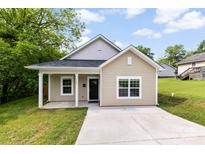 Charming single-story home with light tan siding, white trim, covered porch, and a well-maintained front lawn at 104 E Louisiana Ave, Bessemer City, NC 28016