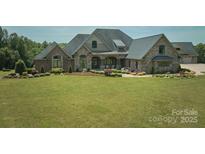 Beautiful stone and brick home featuring a lush green lawn and manicured landscaping at 109 Oak Forest Dr, Kings Mountain, NC 28086