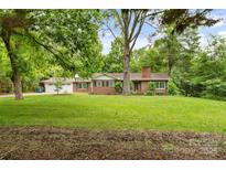 Traditional brick home featuring a manicured lawn and mature trees enhancing its curb appeal at 121 33Rd Ne Ave, Hickory, NC 28601