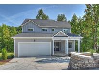 Charming two-story home with a gray exterior, two car garage, and a welcoming front porch at 126 Meadow Glen Dr, Troutman, NC 28166