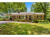 Charming brick ranch home featuring a lush green lawn and a welcoming covered entry at 141 Dunlap Loop, Statesville, NC 28625