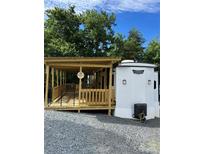 Charming park model with a covered wood porch and gated access, perfect for relaxing outdoors at 152 Eagle Dr # 27B, New London, NC 28127