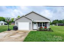 Charming single-story home featuring a one-car garage, grey siding, and well-maintained front lawn at 2411 28Th Ne St, Hickory, NC 28601