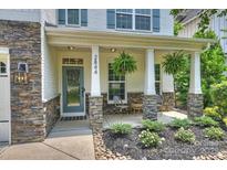 Charming front porch with stone accents, hanging ferns, and seating area offers a welcoming entrance at 2844 Georgia Ave, Charlotte, NC 28205