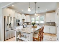 Bright kitchen features stainless steel appliances, granite counters, and a large center island with pendant lighting at 4511 Middlebury Ln, Fort Mill, SC 29715
