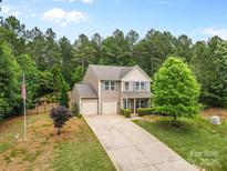 Beautiful home with a two-car garage and an extended driveway in a naturally wooded landscape at 6010 Hawk View Rd, Waxhaw, NC 28173