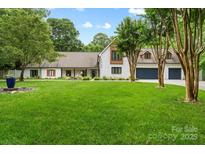 Charming brick home with a well-manicured lawn and mature trees, offering great curb appeal at 7017 S Providence Rd, Waxhaw, NC 28173