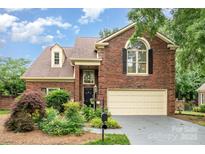 Charming brick home featuring a manicured lawn, two-car garage, and inviting front entrance at 7031 Walton Heath Ln, Charlotte, NC 28277