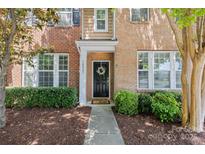 Charming brick home with a welcoming black front door and manicured landscaping at 10027 Juniper Trace Dr, Charlotte, NC 28277