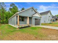Charming single-Gathering home featuring gray siding, an attached garage, and a well-manicured lawn at 101 Churchill Dr, Kings Mountain, NC 28086