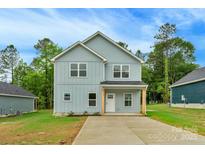 Charming two-story home with light blue siding, a cozy front porch, and a well-manicured lawn at 103 Churchill Dr, Kings Mountain, NC 28086