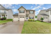 Charming two-story home with a two-car garage, neat landscaping, and a welcoming front porch at 189 Fesperman Cir, Troutman, NC 28166