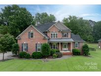 Elegant two-story brick home with a lush green lawn and manicured landscaping at 1912 Windmere Dr, Monroe, NC 28110