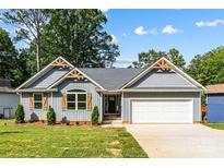 Charming single-story home with light grey siding, wooden accents and a well-manicured lawn at 2027 Marquesas Ave, Tega Cay, SC 29708