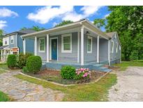 Charming home with a welcoming front porch, complemented by colorful landscaping and a stone walkway at 3400 Reid Ave, Charlotte, NC 28208