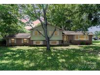 Charming two-story home with brick accents, surrounded by mature trees and a lush lawn at 4250 N Center St, Hickory, NC 28601