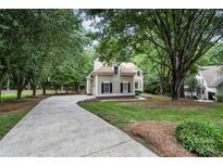 Charming home with mature landscaping and a long driveway leading to the house at 4716 Heatherton Pl, Charlotte, NC 28270