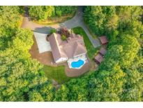 Stunning aerial view of estate home with in-ground pool, sprawling lawn, and mature trees at 560 Blue Sky Dr, Dallas, NC 28034