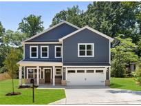 Charming two-story home featuring a well-manicured lawn, an attached two-car garage, and classic curb appeal at 737 Oak St, Charlotte, NC 28214