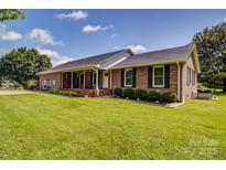 Charming brick ranch-style home with a well-manicured lawn and inviting front porch at 801 Witmore Rd, Wingate, NC 28174