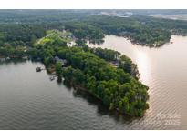 Stunning aerial view of a waterfront property surrounded by lush greenery and shimmering water on Lake Norman at 9184 Greenwood Rd, Terrell, NC 28682