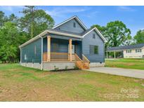 Charming blue home with a wooden porch and a well-maintained front yard at 105 Churchill Dr, Kings Mountain, NC 28086