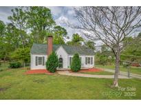 Charming home with a brick chimney, green roof, and a well-manicured front yard at 123 N Poston St, Shelby, NC 28150