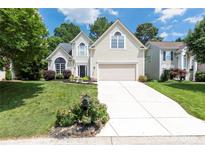 Charming two-story home with a manicured lawn, blossoming flowerbeds, and a driveway leading to a two-car garage at 14218 Springsure Ct, Huntersville, NC 28078