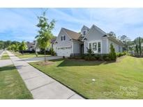 Charming single-story home with manicured lawn, stone accents, and two-car garage at 14531 Crosswater Ln, Charlotte, NC 28278