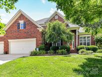 Beautiful brick home boasts a well-manicured lawn, lush landscaping, and attached two-car garage at 15929 Northstone Dr, Huntersville, NC 28078