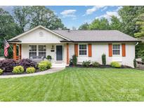 Charming single story home with manicured lawn, tidy landscaping, and decorative, rustic orange window shutters at 1621 Brookdale Ave, Charlotte, NC 28210