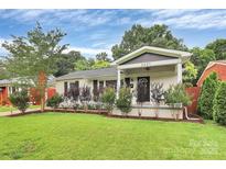 Charming single-story home featuring a covered porch and well-manicured front lawn at 2421 Shamrock Dr, Charlotte, NC 28205