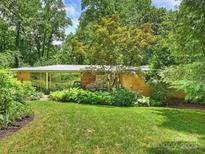 Beautifully landscaped front yard featuring a brick home with lots of natural light and lush greenery at 2600 Cloister Dr, Charlotte, NC 28211