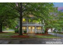 Inviting two-story home featuring a charming front porch and lush, mature landscaping at 3007 Colonel Springs Way, Fort Mill, SC 29708
