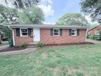 Charming single-story brick home with a well-manicured lawn and mature trees in a serene neighborhood at 4209 Donnybrook Pl, Charlotte, NC 28205
