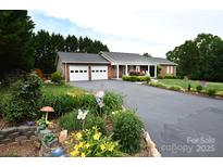 Charming brick home featuring a two-car garage, landscaped front yard, and inviting front porch at 4646 River Run Cir, Hickory, NC 28602
