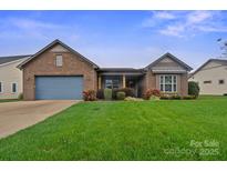 Charming single-story brick home with a well-manicured lawn, blue garage door, and inviting front porch at 499 Granite Lake Ct, Denver, NC 28037