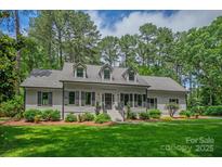 Charming single-story home with lush green lawn, dormer windows, and mature trees at 516 Amanda Dr, Weddington, NC 28104